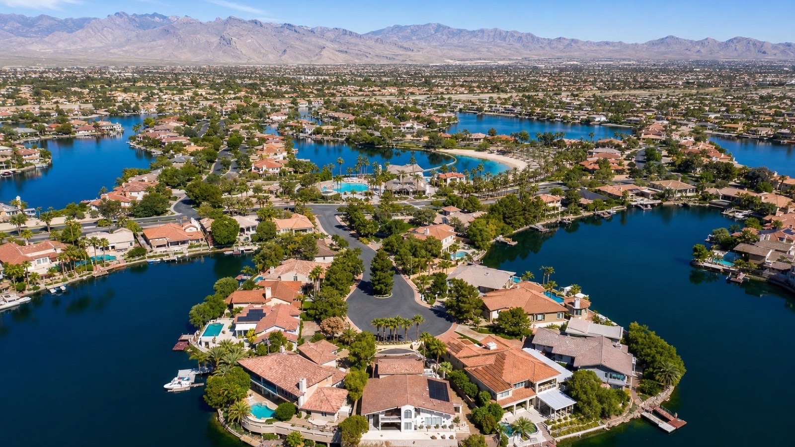 Desert Shores northwest Las Vegas private lake with lakefront homes and paddleboats at golden hour